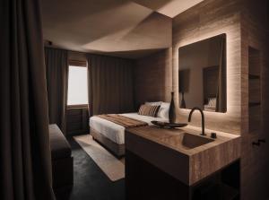 a hotel room with a bed and a sink at Casa Cook Madonna - Adults Only in Madonna di Campiglio