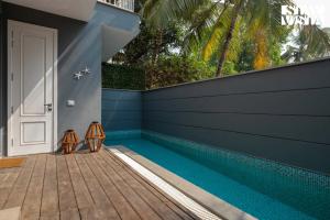 a swimming pool in a house with a blue wall at StayVista at Casa Vida Zeo with BBQ, Pool, WiFi in Assagao