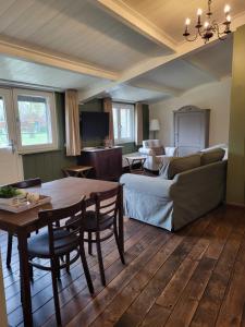 a living room with a table and a couch at De Turfstaeker in Ospel