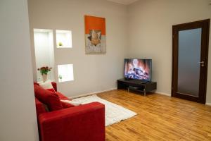 a living room with a red couch and a television at Rataskaevu 6 Apartment in Tallinn
