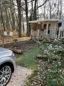 a small cabin with a car parked in front of it at Au petit paradis in Camiers