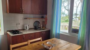 Una cocina con una mesa y un fregadero y una ventana. en Shekvetili Sun, en Shekhvetili