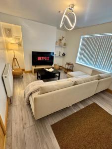 Una sala de estar con un sofá y un televisor. en Fortune Haven- 3BDR HOME- Special Offer 4 Contractors & Long Stay- dm, en Nottingham