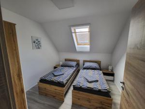 2 camas individuales en un ático con ventana en Galamb Vendégház, en Vonyarcvashegy