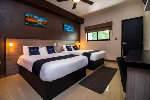 a hotel room with two beds and a desk at Collection O Hotel Mango,Six Flags Hurricane Harbor Oaxtepec in Oaxtepec