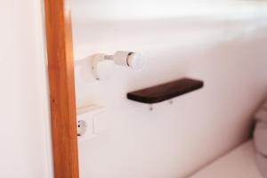 a bathroom with a toilet paper dispenser on the wall at Ocean Nomads Coworking in Arona