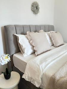 a gray bed with white pillows and a vase with a flower at Romantic 3 Bedroom Apartment 3min from the beach in Kruševo