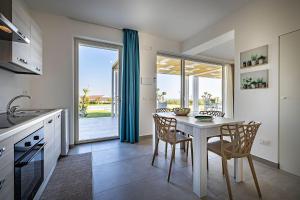a kitchen with a table and chairs and a kitchen with a window at Shalamu Luxury Apartments in Rosolini +60 photos