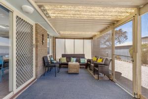 ArdrossanArdrossan Hotel Motel的带桌椅的封闭式门廊