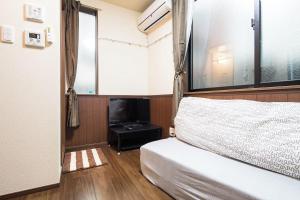 a bedroom with a bed and a tv in it at Central Shinjuku, Quiet Area, Close to Station, No Stairs, Room101 in Tokyo