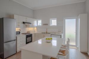 cocina con electrodomésticos blancos y encimera blanca en Seaside Escape at The Dunes: Walk to Beach Braai, en Plettenberg Bay