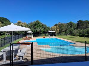 una piscina con una valla alrededor en Seaside Escape at The Dunes: Walk to Beach Braai, en Plettenberg Bay