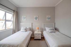 Dos camas una al lado de la otra en un dormitorio. en Seaside Escape at The Dunes: Walk to Beach Braai, en Plettenberg Bay 14 fotos más