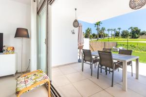 a dining room with a table and chairs at Apartamento bajo luxury golf Baviera Hills 54 in Caleta De Velez