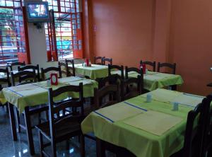 Habitación con mesas, sillas y mantel verde. en Hotel Toraryca, en Belém