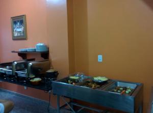 a buffet line with food in a hotel room at Hotel Toraryca in Belém