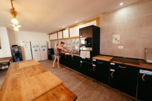 a woman standing in a kitchen preparing food at Ocean Nomads Coworking in Arona