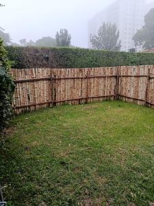a wooden fence in a yard with a green grass at Woods Cottage Kilimani in Nairobi