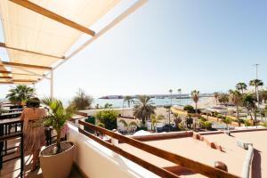 a woman standing on a balcony looking out at the ocean at Ocean Nomads Coworking in Arona