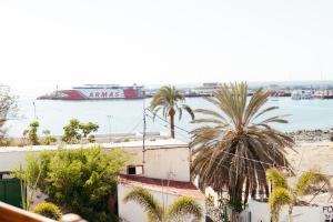 a view of a harbor with palm trees and a ship at Ocean Nomads Coworking in Arona