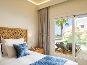 una camera d'albergo con un letto e una porta scorrevole in vetro di Anax Resort and Spa ad Agios Ioannis