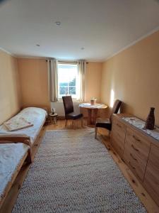 AhlbeckにあるNEU! Ferienwohnung Ahlbeck - Stettiner Haffのベッド2台とテーブルと窓のある部屋