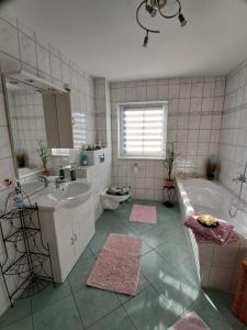 AhlbeckにあるNEU! Ferienwohnung Ahlbeck - Stettiner Haffの浴槽と洗面台とバスタブを備えたバスルーム +14枚の写真