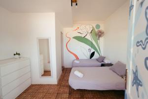 a living room with a couch and a flower painted on the wall at Ocean Nomads Coworking in Arona