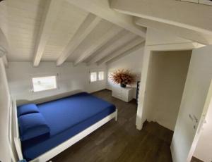 a bedroom with a blue bed in a attic at FIORDO 448 in Isola Albarella