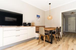 ein Esszimmer mit einem Tisch und einem Flachbildfernseher in der Unterkunft Am Hof 3 in Staberdorf