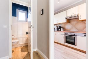 eine Küche mit weißen Schränken und einer Spüle in der Unterkunft Am Hof 3 in Staberdorf + 35 Fotos