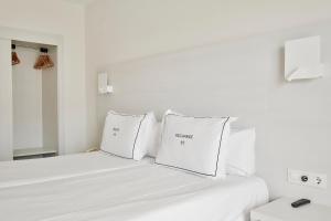 a white bed with two white pillows on it at Helios Mallorca Hotel & Apartments in Can Pastilla