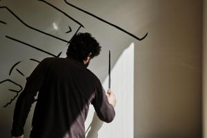 a man standing in a room with arrows on the wall at Helios Mallorca Hotel & Apartments in Can Pastilla