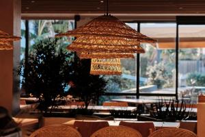 a chandelier in a restaurant with tables and chairs at Helios Mallorca Hotel & Apartments in Can Pastilla
