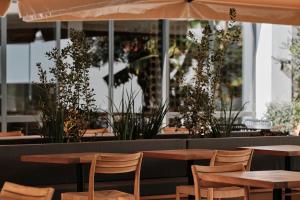 a restaurant with wooden tables and chairs and plants at Helios Mallorca Hotel & Apartments in Can Pastilla