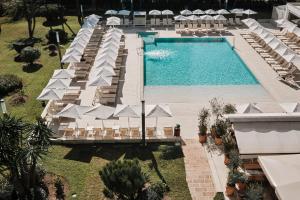 an overhead view of a swimming pool with lounge chairs and a resort at Helios Mallorca Hotel & Apartments in Can Pastilla