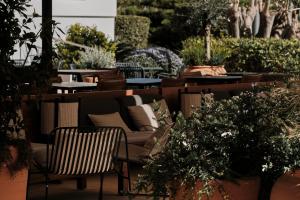a patio with tables and chairs and plants at Helios Mallorca Hotel & Apartments in Can Pastilla