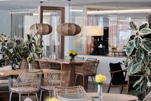 a dining room with tables and chairs and potted plants at Helios Mallorca Hotel & Apartments in Can Pastilla