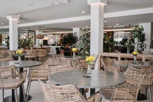 a restaurant with tables and chairs with flowers on them at Helios Mallorca Hotel & Apartments in Can Pastilla