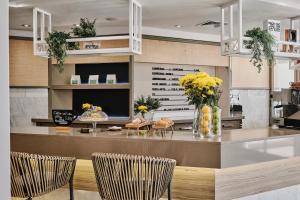 a kitchen with two chairs and a counter with flowers at Helios Mallorca Hotel & Apartments in Can Pastilla