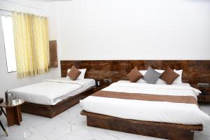 Postel nebo postele na pokoji v ubytování Hotel Morvi Nandan