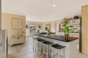 a kitchen with a large island with bar stools at Knysna - Views Views Views! in Knysna