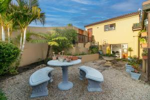 a small patio with a table and two benches at Knysna - Views Views Views! in Knysna