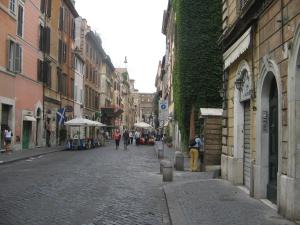 eine Kopfsteinpflasterstraße mit Leuten, die die Straße entlang gehen in der Unterkunft Rome Services Borgo Suites in Rom