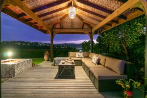 a wooden deck with a couch under a wooden pergola at Knysna - Views Views Views! in Knysna
