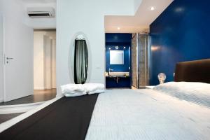 Schlafzimmer mit blauen Wänden, einem Bett und einem Waschbecken in der Unterkunft Rome Services Borgo Suites in Rom