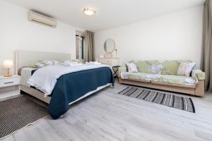 sypialnia z łóżkiem i kanapą w obiekcie Apartment Stella Marina Sea view Free Parking w Rovinj