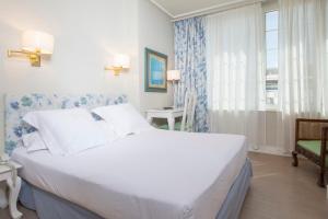a bedroom with a large white bed and a window at Hotel Niza in Donostia-San Sebastián