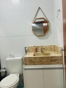 a bathroom with a toilet and a sink and a mirror at Margarida 02 in Monte das Gameleiras