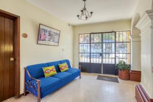 a blue couch in a living room with a window at Capital O Parador Crespo Hotel, Oaxaca in Oaxaca City